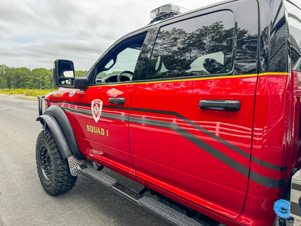 Door emblem close-up on the cab with side striping and mirror mount.
